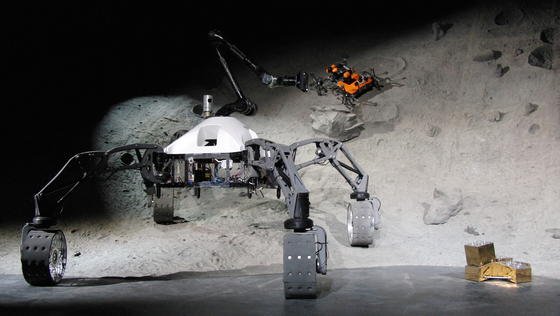 Die am Weltraumszenario beteiligten mobilen Systeme SherpaTT (vorne), Coyote III (hinten im Krater) und die Basisstation mit aufgestecktem Nutzlastmodul (re.).