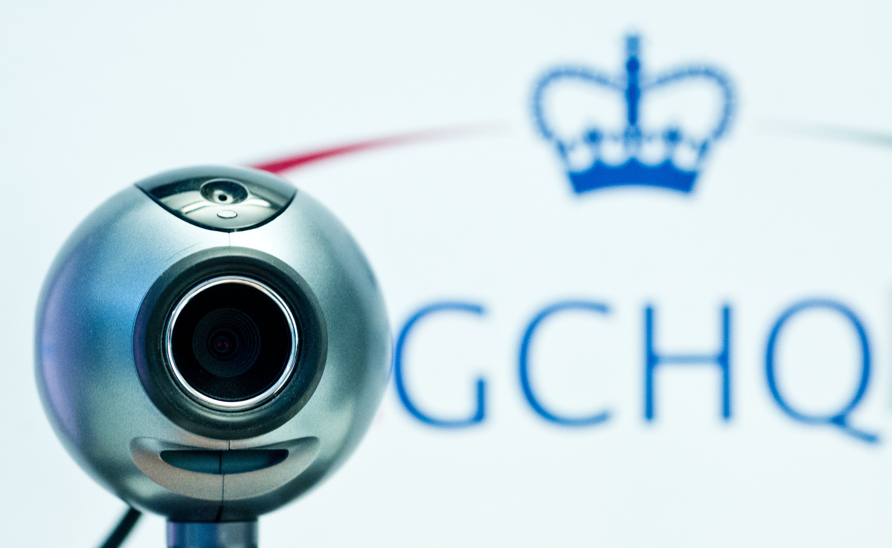 Eine Webcam vor dem Logo des britischen Geheimdienstes Government Communications Headquarters (GCHQ). Die britische Regierung hat zugegeben, dass ihr Abhördienst GCHQ im großen Stil den Internetverkehr wie etwa die Google-Suchen oder die Facebook-Aktivitäten britischer Bürger anzapft. 
