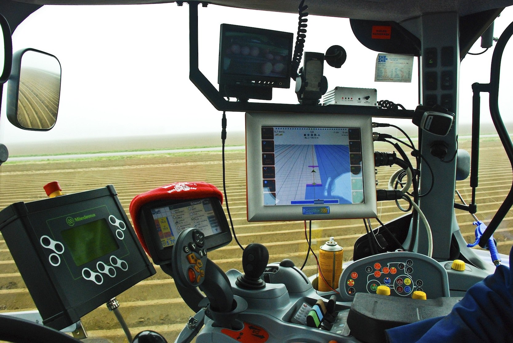 Traktor-Cockpit mit Displays: Künftig sollen Satellitendaten ein effizienteres Bearbeiten von Ackerflächen erlauben.