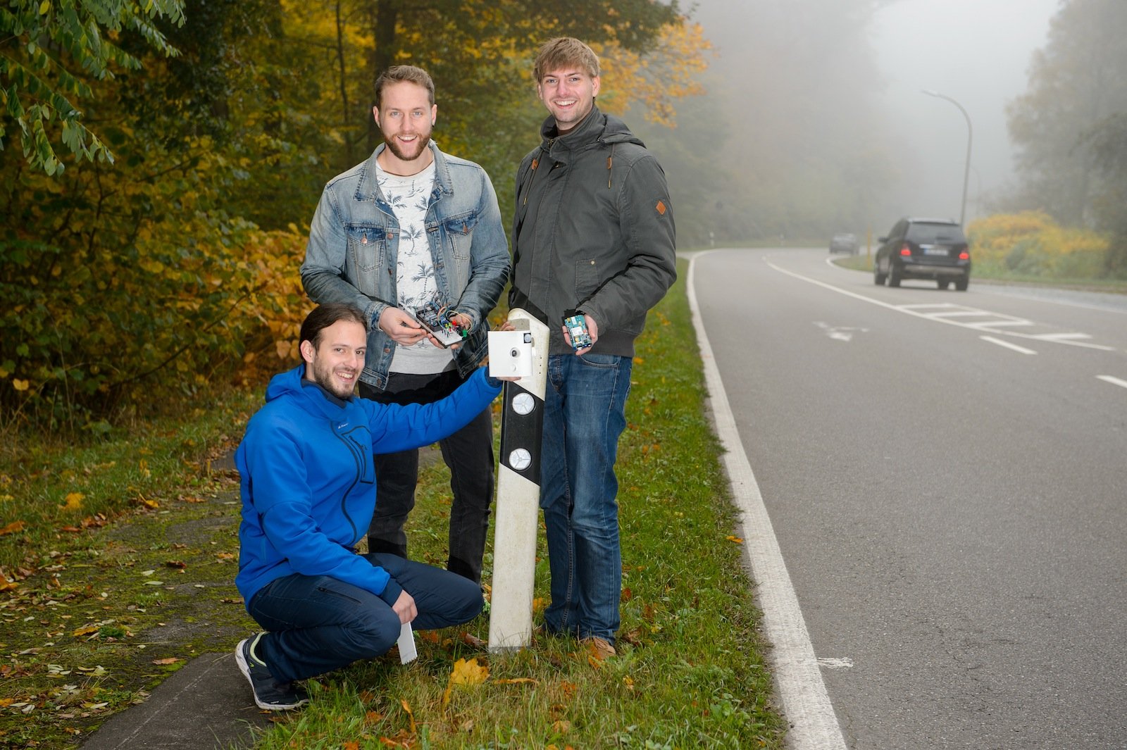 Die Studenten Benjamin Kirsch (kniend), Julian Neu (Mitte) und Daniel Gillo (r.) haben ein solarbetriebenes Sensorsystem entwickelt, das Falschfahrer früh erkennt und Warnungen veranlassen kann. 