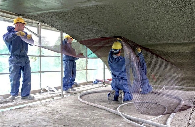 Diese Brücke wird mit Betonkarbon saniert. Die Bauarbeiter tragen gerade das Karbongitter auf.  Brücke Naila wird mit Karbonbeton saniert.