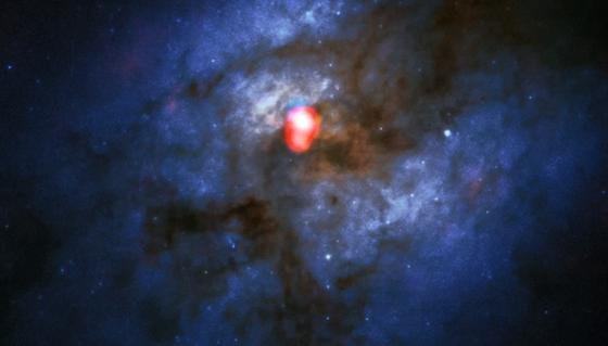 Dieses Kompositbild zeigt eine neue Alma-Band-5-Aufnahme des kollidierenden Galaxiesystems Arp 220 (in rot) über einem Bild des Hubble-Weltraumteleskops (blau/grün). Mit den neu installierten Band-5-Empfängern blickt Alma auf einen ganz neuen Teil dieses Radiospektrums und verbessert die Möglichkeit des Teleskops im Universum nach Wasser zu suchen. Dieses Bild ist eines der ersten, beim dem das Band 5 verwendet wurde.