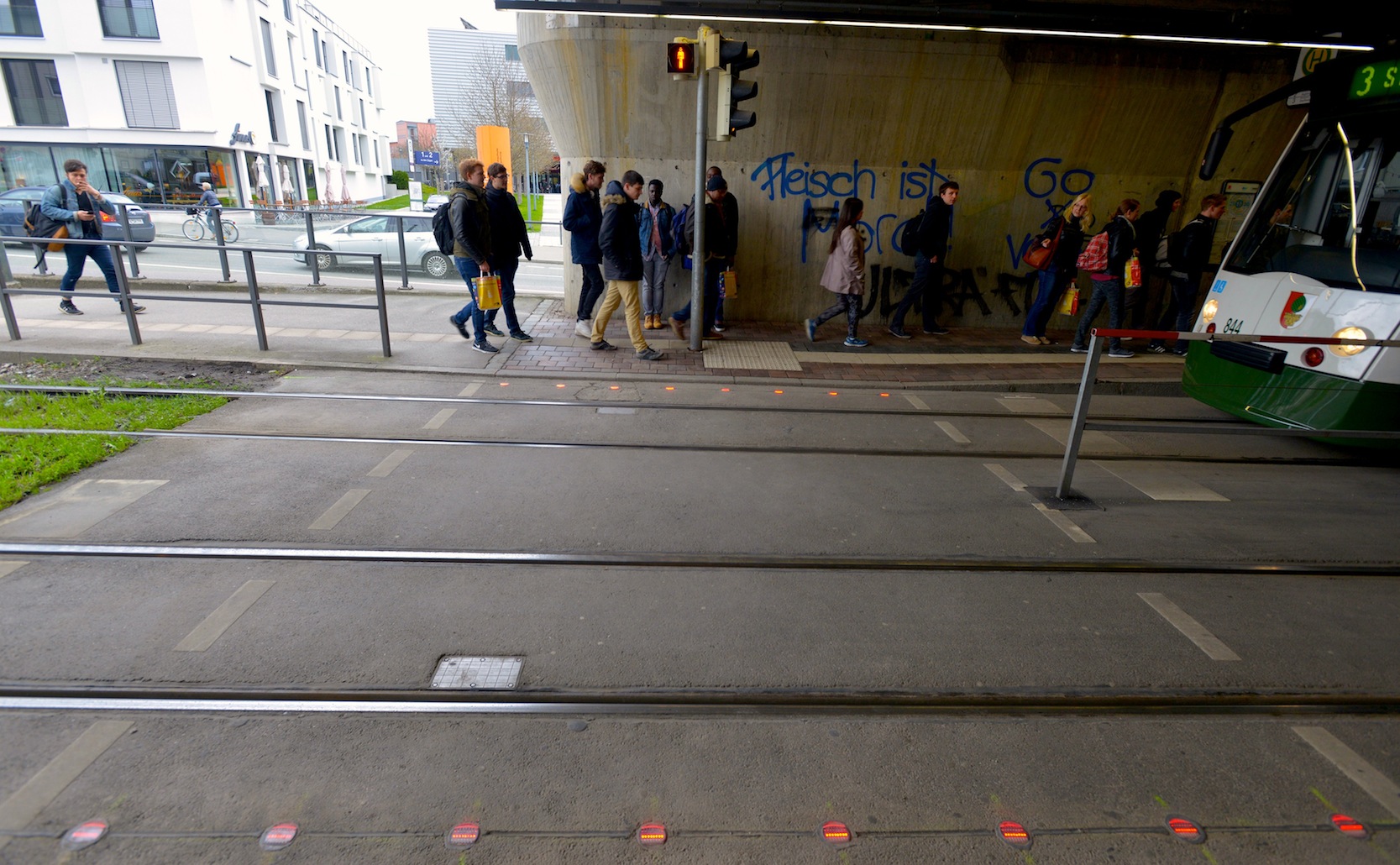 In Augsburg warnen rote LED-Leuchten im Boden abgelenkte Fußgänger, die auf ihr Smartphone starren, vor der Straßenbahn.