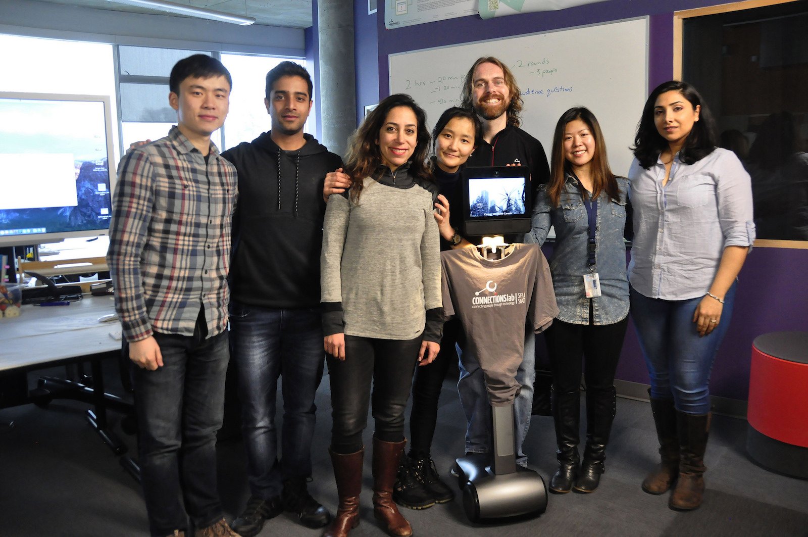 Prof. Carman Neustaedter (3.v.r.) und sein Team mit einem der Telepräsenzroboter.