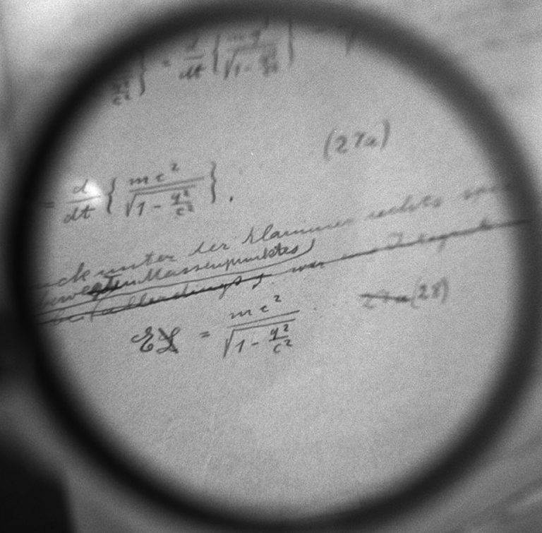 Albert Einsteins Berechnungen zur Relativitätstheorie (E=mc2) sind unter einem Vergrößerungsglas auf dem Manuskript zu sehen.