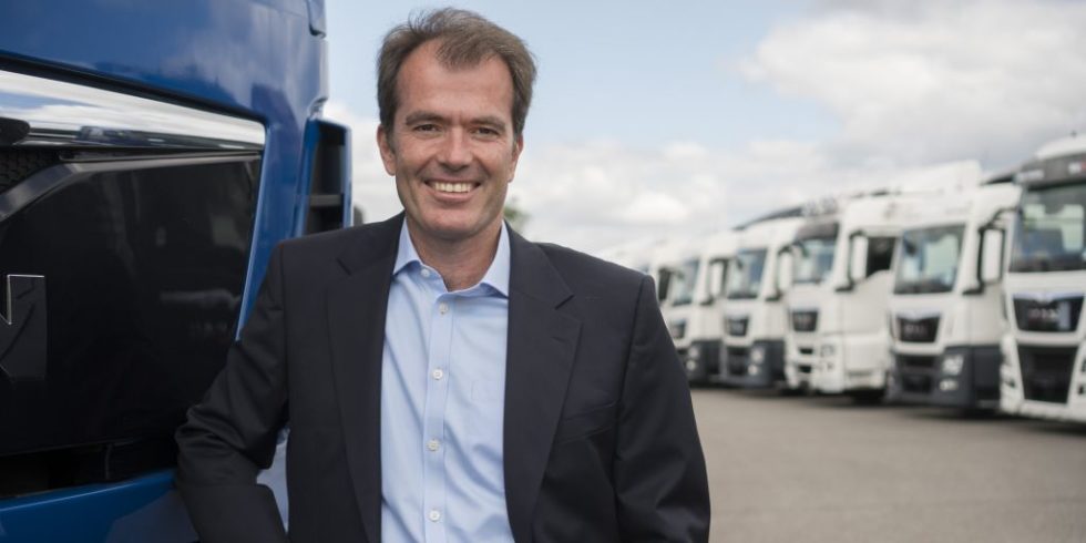 Rolf-Dieter Lafrenz steht vor einer Lkw-Flotte