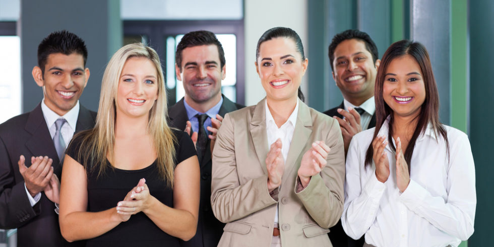 Ein Team aus sechs Personen in Businesskleidung applaudiert