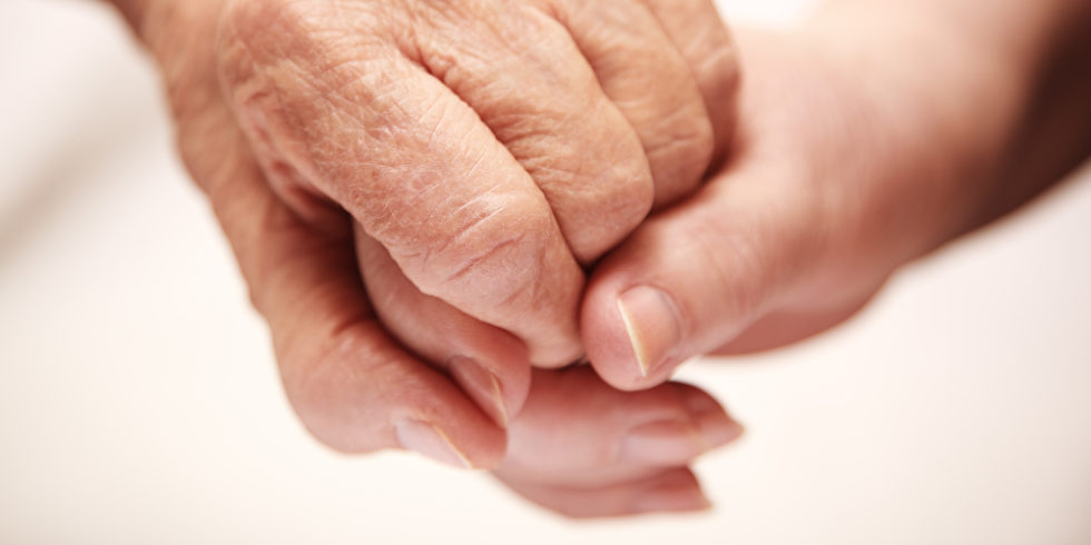 Symbolbild zum Thema Pflege von Angehörigen. Zwei Hände, eine junge und eine alte greifen ineinander