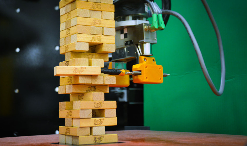 Industrieroboter greift Holzklötzchen beim Jenga-Spiel