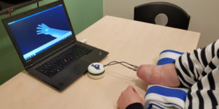 Patientin vorm Computer, die eine virtuelle Hand steuert