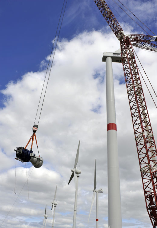 Der Generator wird mithilfe eines Krans in die Anlagengondel eingebaut.