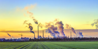 Industrietürme mit Rauch am Horizont