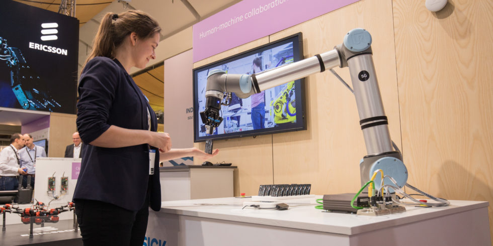 Besucherin erhält am Ericsson-Stand Bonbons vom Produktionsroboter.<br srcset=