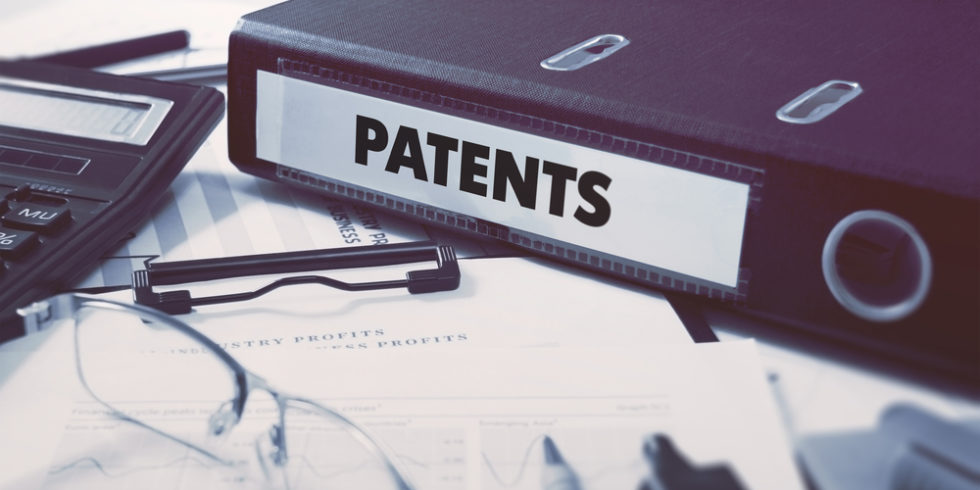 Patentordner auf Schreibtisch mit Brille und Papieren