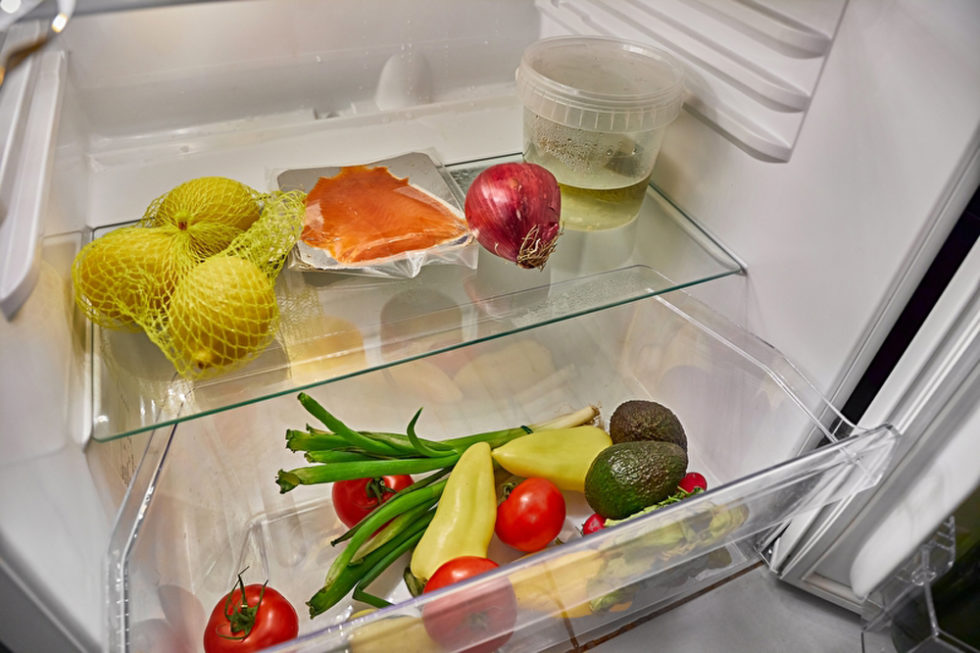 Blick in den Kühlschrank mit Obst und Fisch.