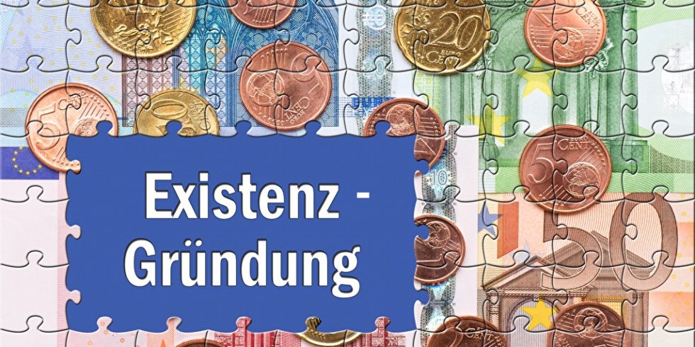 Kosten für die Selbstständigkeit veranschaulicht durch den Schriftzug Existenz-Gründung auf einem Puzzle aus Geld