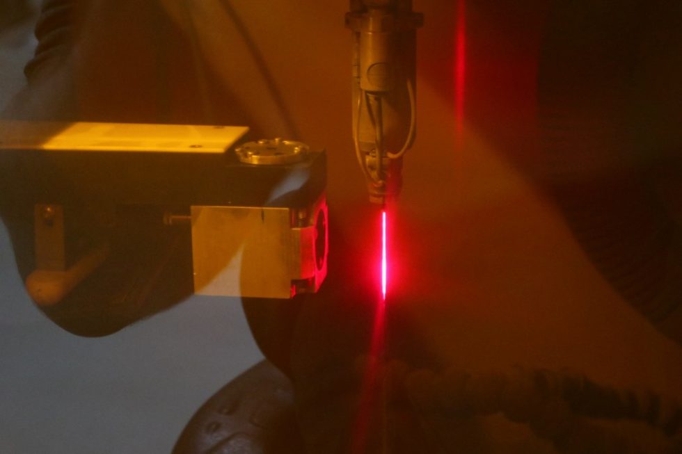 Die Qualität der Düsenöffnung wird beim LMJ-Laser indirekt durch Analyse der Raman-Strahlung erfasst. Links der Sensor, rechts der durch das Laserschutzfenster rot erscheinende LMJ-Strahl. Foto: Synova