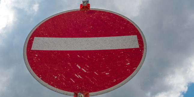 Durchfahrt-verboten-Schild vor wolkigem Himmel