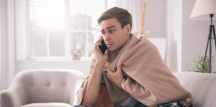 Mann krank in Decke am Telefon