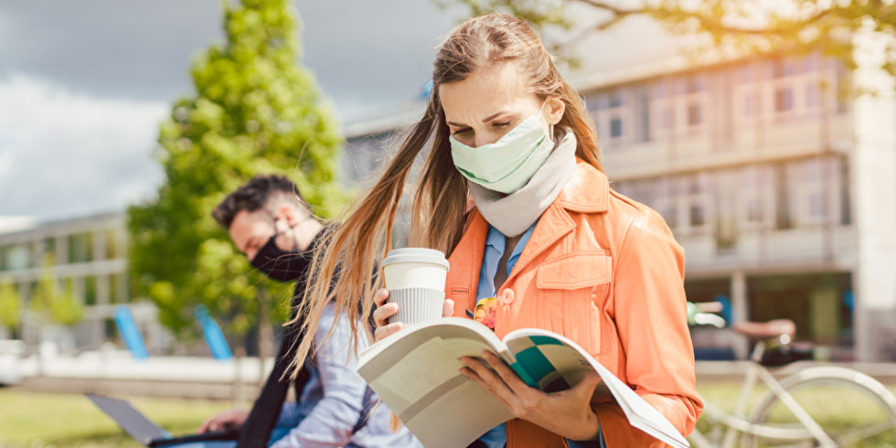 Studentin mit Maske und Büchern