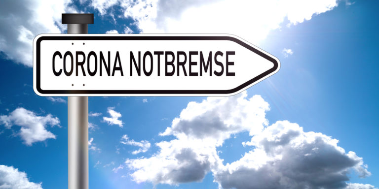 Schild Schrift Corona Notbremse