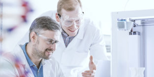 zwei Studierende am 3D-Drucker