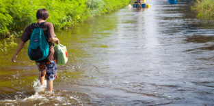 Frau watet durch überflutete Straße