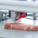 Perfekte Imitation. die Nahaufnahme eines modernen 3D-Druckers der ein Stück Fleisch herstellt und alle Details genau imitiert
