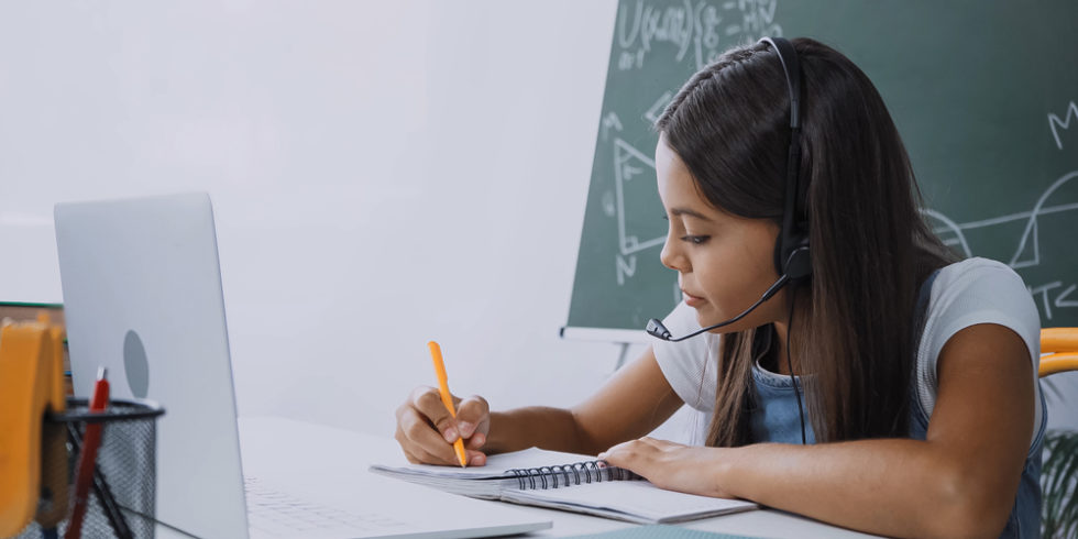 Schülerin mit Headset und Laptop