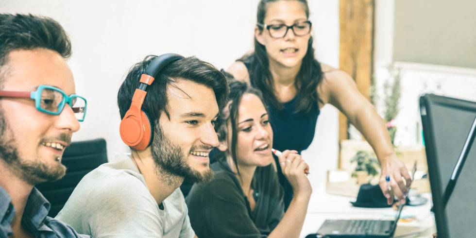 Junge Leute zusammen in einem Raum am Computer