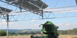 Mähdrescher unter Solarmodulen