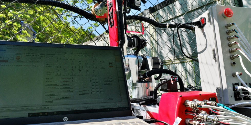 Intelligente Sensortechnik: Der Roboter wird per Laptop bewegt und kann so beispielsweise ein Rütteln am Zaun imitieren, das die Sensoren im Kabel registrieren. Dieser Versuchsaufbau ist auf der Hannover Messe zu sehen. Foto: Universität des Saarlandes/Thorsten Mohr