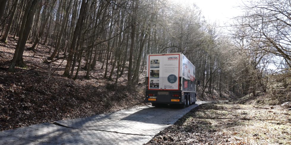 Das Einsatzfahrzeug rollt über den mit Stahlplatten verstärkten Waldweg zur Baustelle. Foto: URETEK Deutschland GmbH