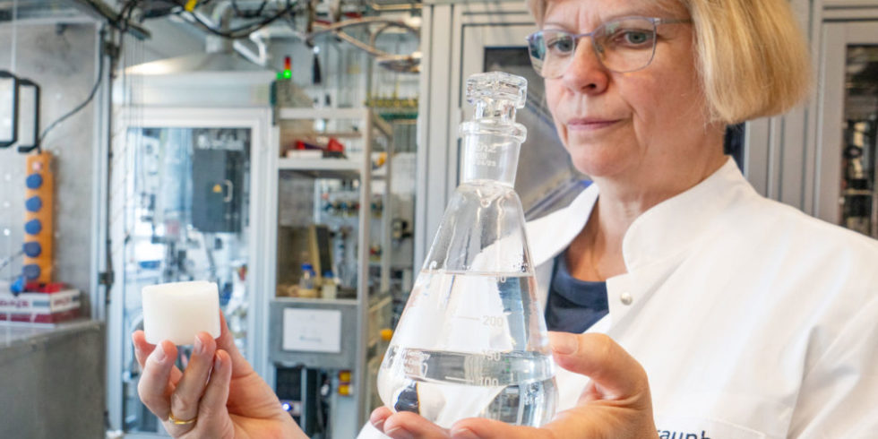 Forscherin hält biogenen Kraftstoff und Wachs in den Händen