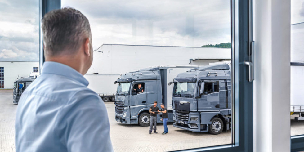 Flottenmanager blickt auf Lkw und Fahrer