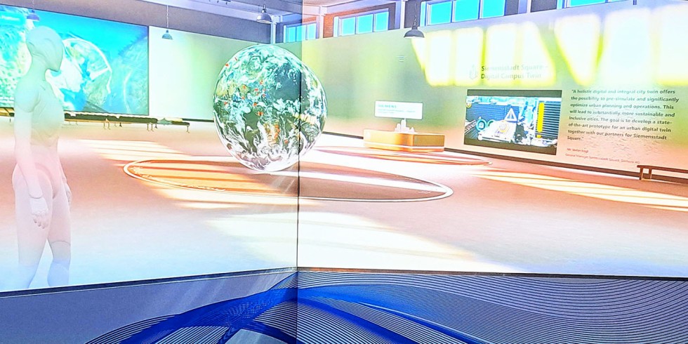 Eintauchen in virtuelle Welten: Planer können sich mithilfe ihrer Avatare in einem 3D-Universum treffen und bewegen, um die digitalen Zwillinge von Infrastruktur oder Gebäuden zu begutachten. Bei dieser iLab-Demonstration von Bentley Systems in London ist als Beispiel im Hintergrund der digitale Zwilling der Siemensstadt Berlin zu sehen, wo bis 2035 ein Campus entstehen soll. Foto: VDI Fachmedien / K. Klotz