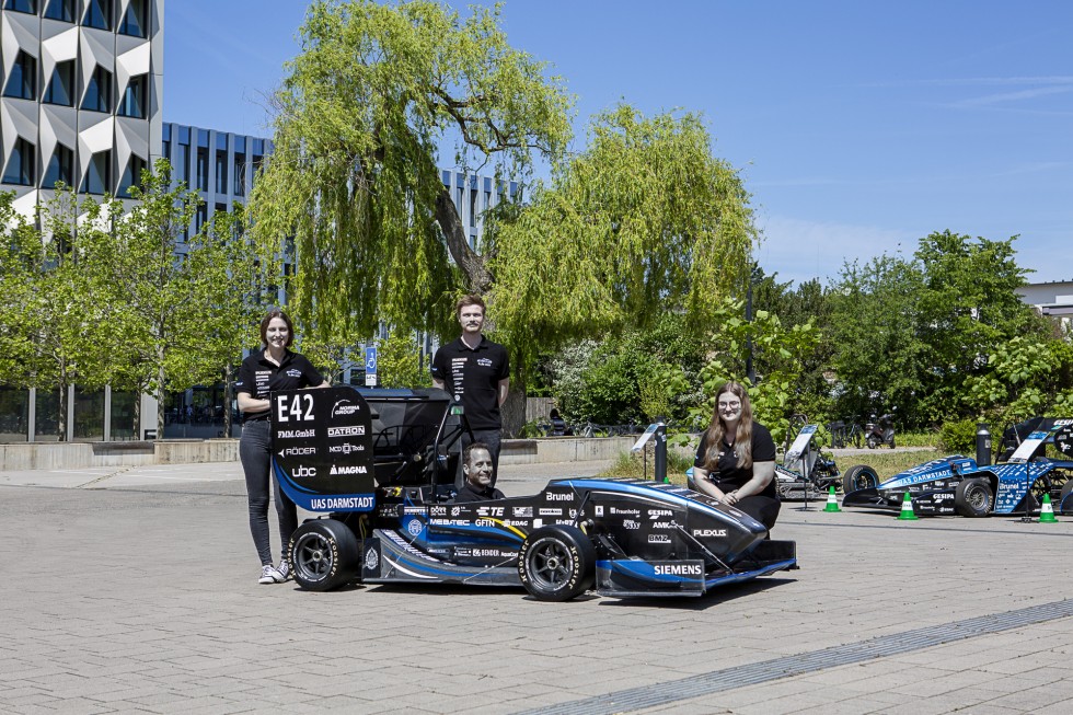 Das Formula Student Team der h_da am neuen Rennwagen "F 23": Studentischer Projektleiter Jonas Acker (Mitte stehend), Michelle Peters (links) und Vanessa Kreß (rechts) aus der Finanzleitung und sitzend Prof. Dr. Florian Van de Loo, Faculty Advisor. Foto: Hochschule Darmstadt/Samira Schulz