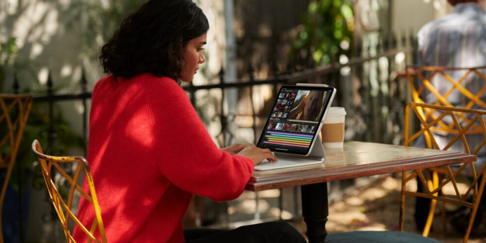 Frau sitzt am Tisch mit iPad Pro von Apple