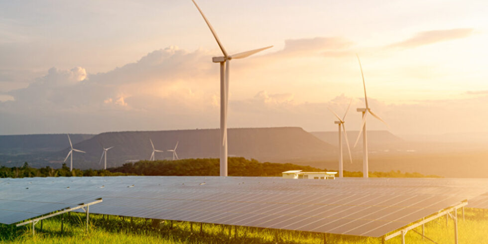 PV- und Windkraftanlagen vor Landschaft mit Abendhimmel