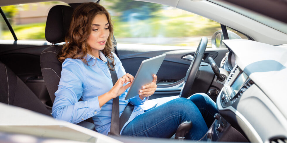 Frau mit Tablet im Auto