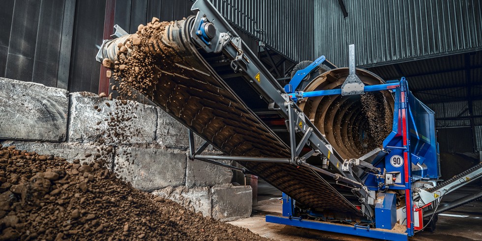 In der 4.500 m2 großen Behandlungshalle wird das Bodenmaterial mit der Trommelsiebanlage zu wertvollem Ersatzbaustoff aufbereitet. Foto: Bauer Gruppe