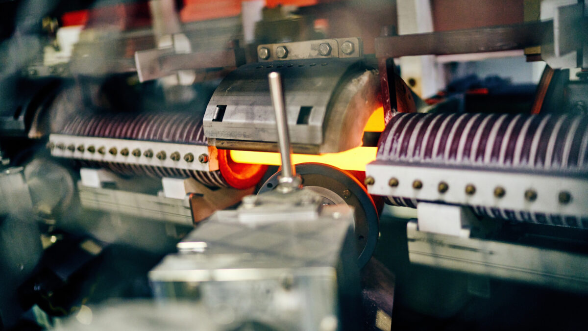 Die Zukunft des Vergütens von Stahlstäben: Induktionsspulen heizen in Georgsmarienhütte einen Stahlstab auf gut 900 °C auf. Foto: GHM-Gruppe