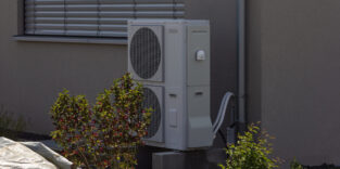 Eine Wärmepumpe vor einem Einfamilienhaus.