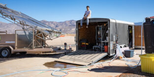 Jon Bessette sitzt auf einem Anhänger, der das Elektrodialyse-Entsalzungssystem beherbergt