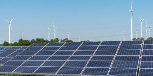 Freiflächensolaranlage steht vor einigen Windkraftanlagen. Ein Symbolbild für mehr erneuerbare Energien in Deutschland.