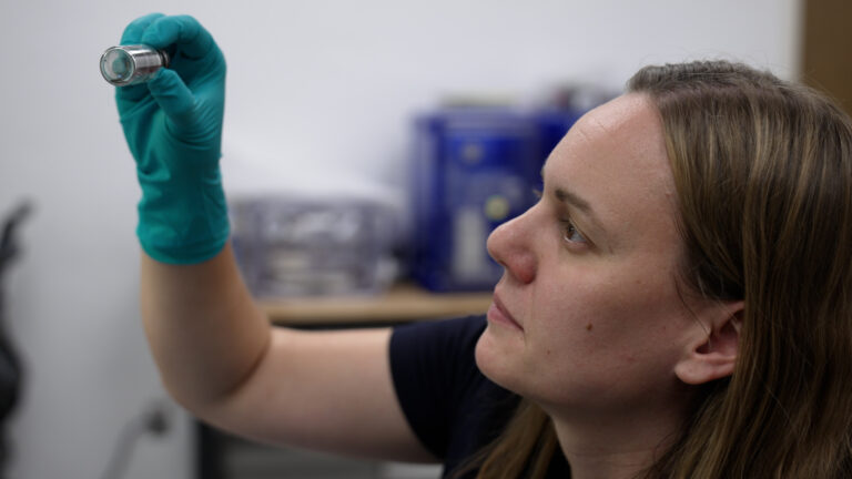 Jessica Barnes untersucht eine Ampulle mit Partikelproben im Kuiper-Arizona Laboratory for Astromaterials Analysis an der University of Arizona