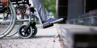 Ein Rollstuhl steht an einer Kante.