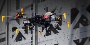 Flugroboter mit modularen Bauelementen vor einer Testwand