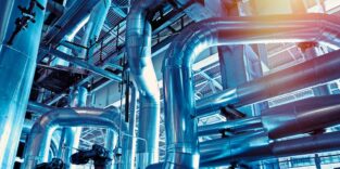 Blick in eine Industrieanlage mit großen Rohrleitungen als Symbolbild für die Chemieindustrie.