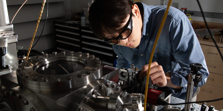 Dongchel Shin, Doktorand im Bereich Maschinenbau und Hauptautor einer neuen Veröffentlichung, die die Laserkühlung eines zentimeterlangen Torsionsoszillators demonstriert, arbeitet an einer optischen Anlage.